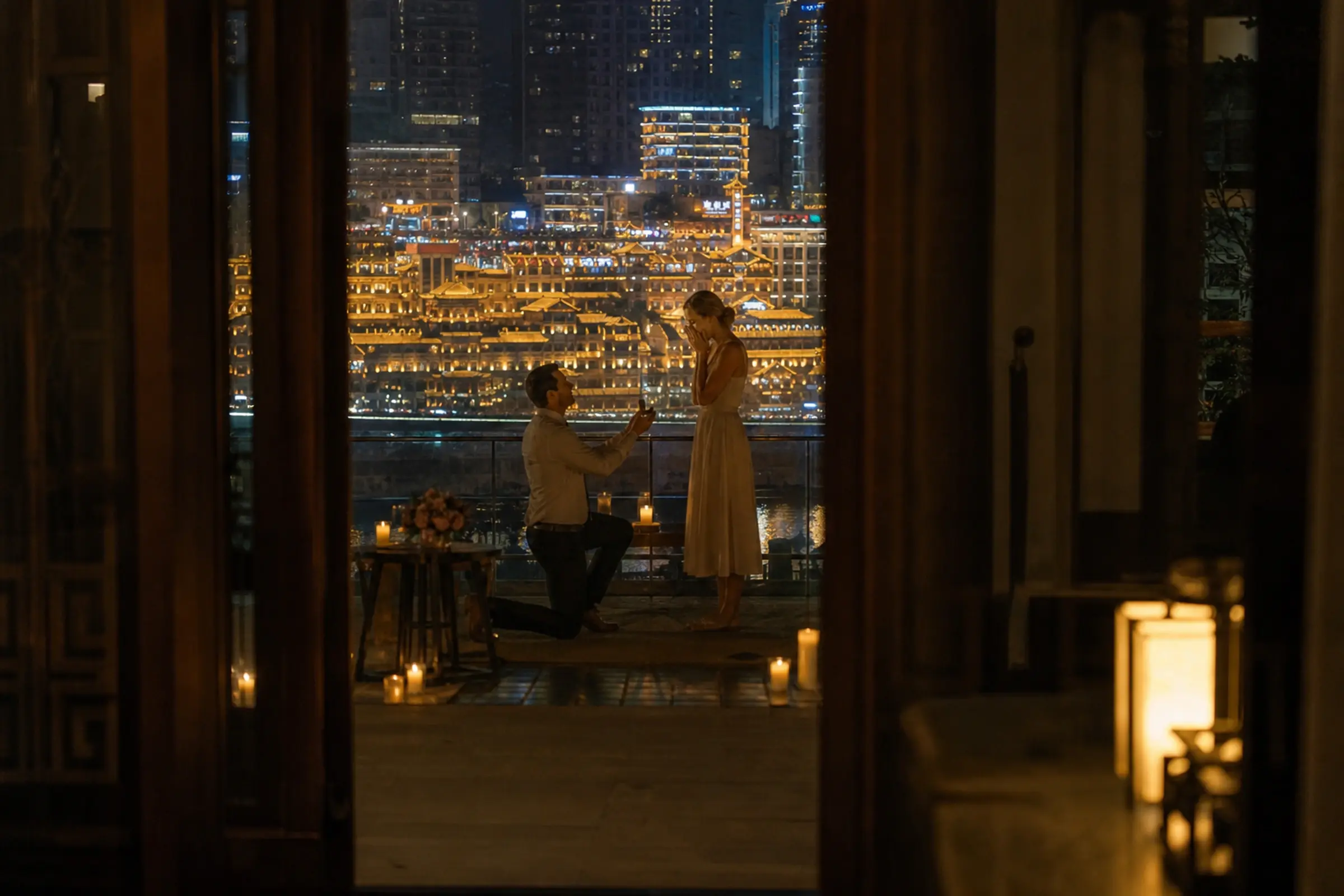 Seen through a doorway: a proposal on a candlelit terrace, Hongyadong glowing across the river