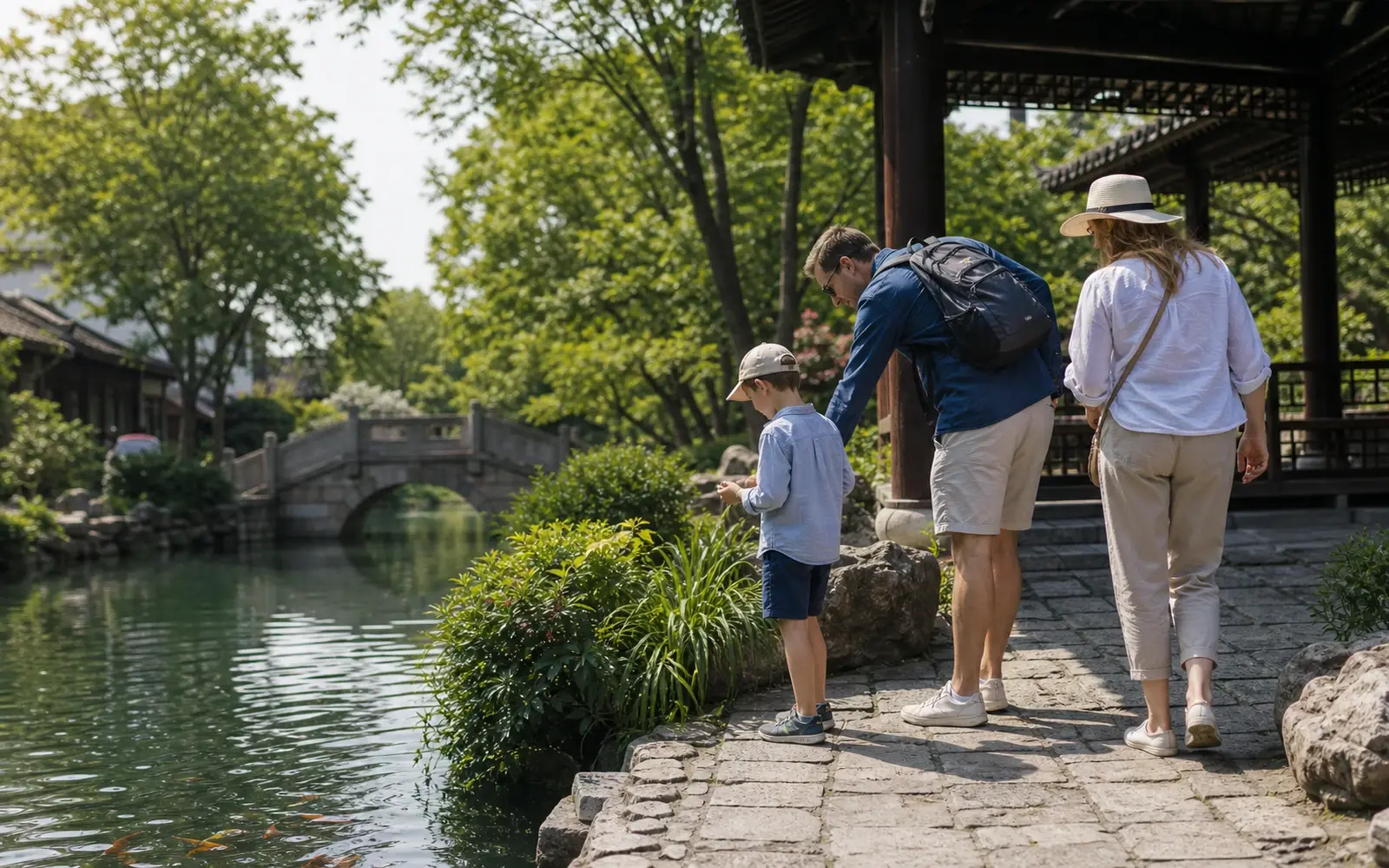 A family pausing beside a pond in a classical Chinese garden