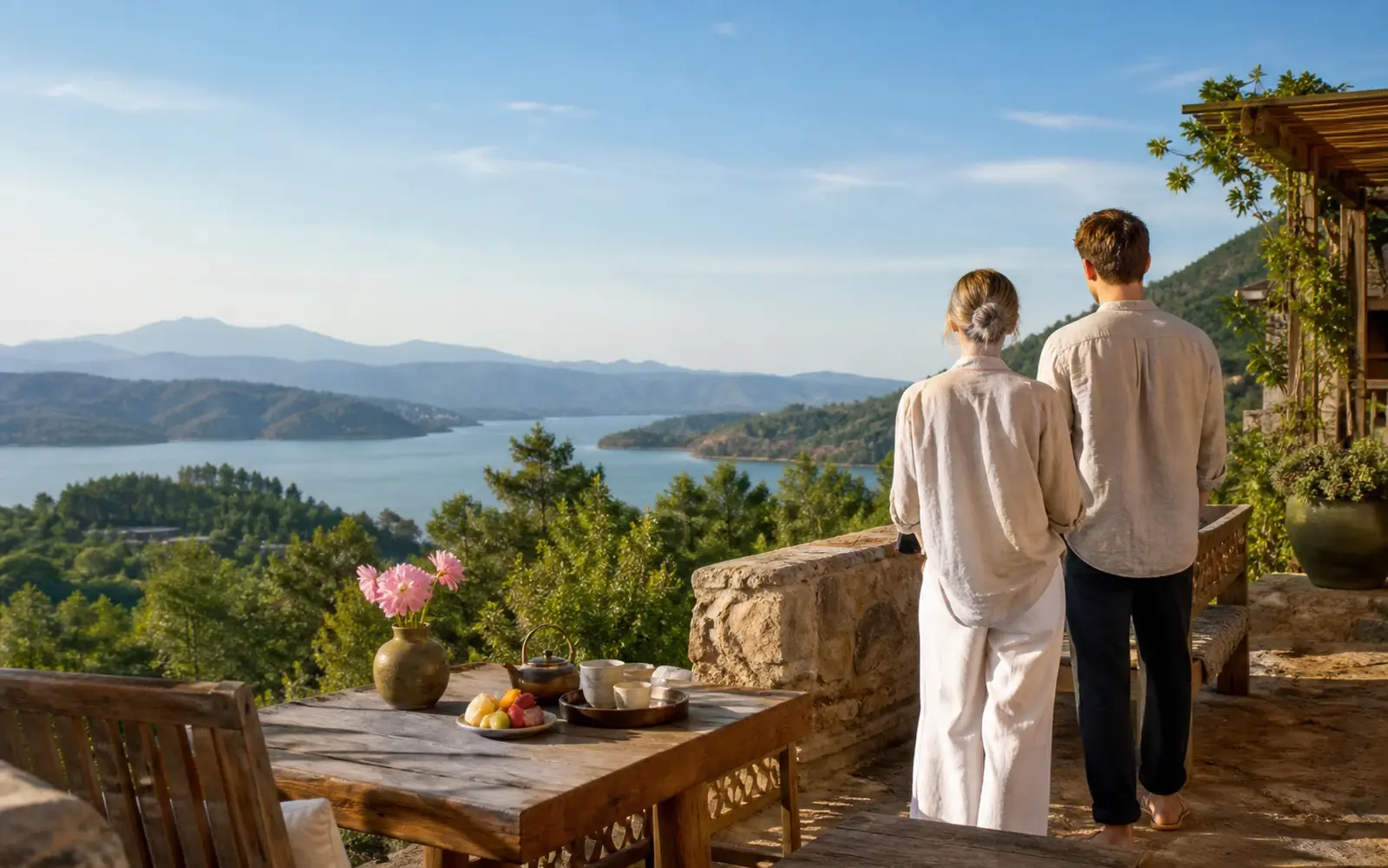 A couple overlooking a quiet lake from a stone terrace