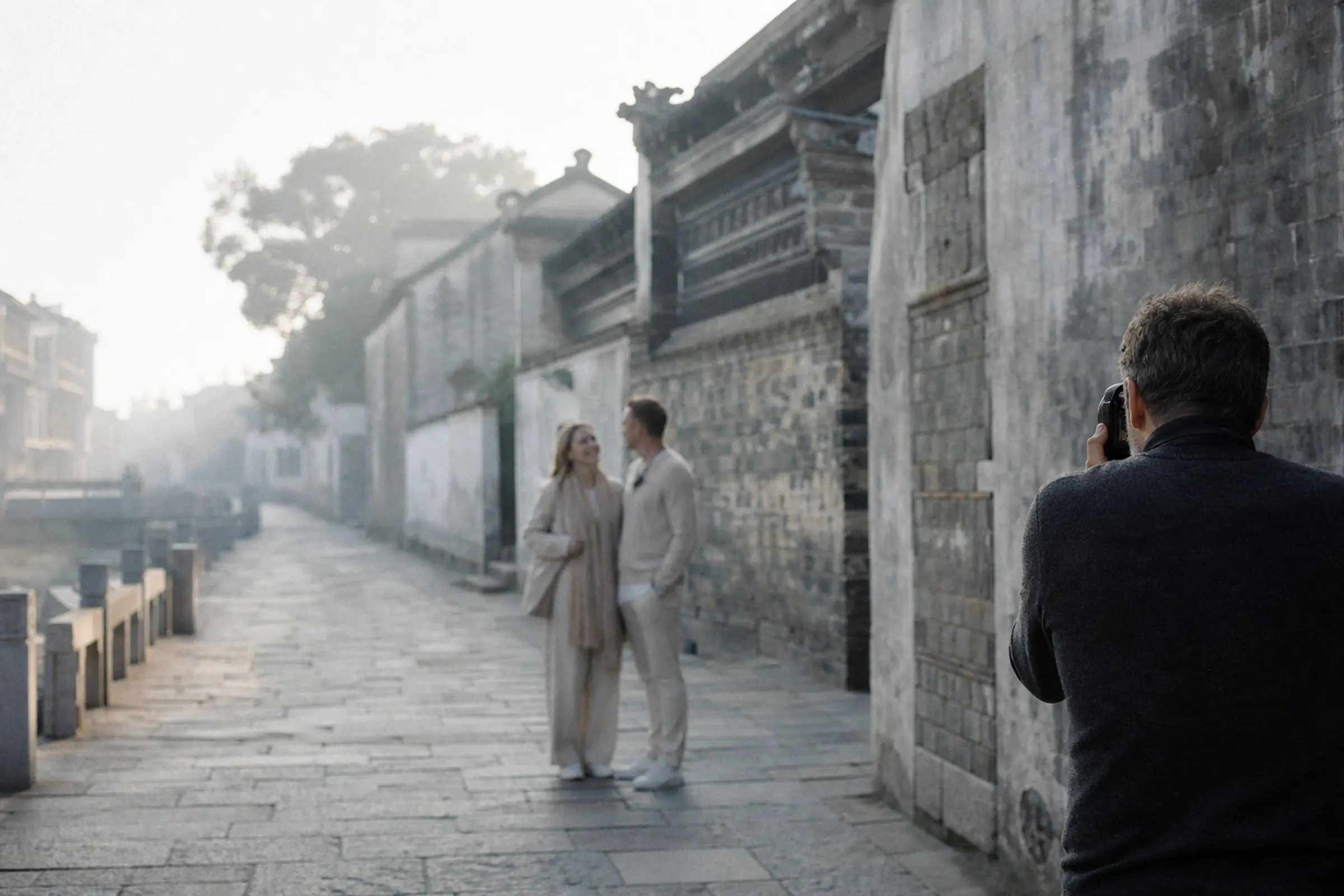 摄影师在雾气里的石板巷中安静地拍一对情侣